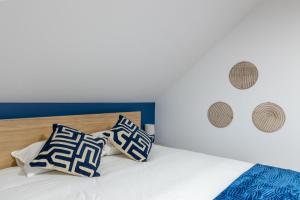 a bed with blue and white pillows on it at La Perle Bleue in Algrange