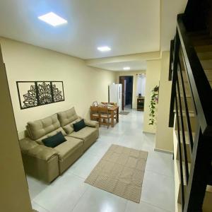 a living room with a couch and a table at Casa completa com 2 quartos e garagem perto do aeroporto in Joinville