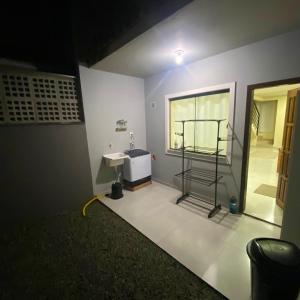 a room with a bathroom with a sink and a window at Casa completa com 2 quartos e garagem perto do aeroporto in Joinville +17 photos