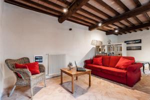 a living room with a red couch and a table at Borgo Cerbaiola in Montecastelli
