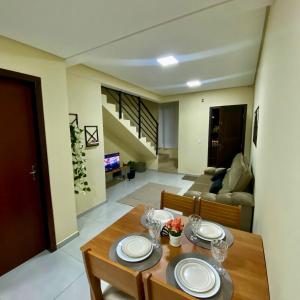 a dining room and living room with a table at Casa completa com 2 quartos e garagem perto do aeroporto in Joinville