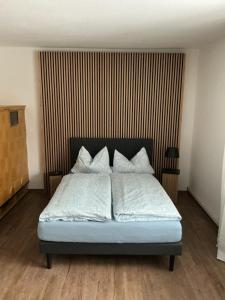 a bedroom with a bed with white sheets and pillows at Ferienwohnung am Netzener See in Lehnin
