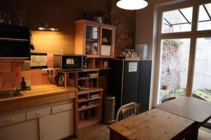 a kitchen with a black refrigerator and a table at schickSAAL* in Lübeck