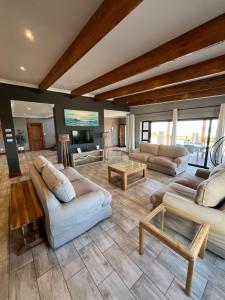 a large living room with couches and a table at Oppi See Beach House in Wilderness