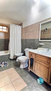 a bathroom with a toilet and a sink and a tub at Isla Bella in Ushuaia +25 photos
