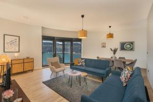 a living room with a blue couch and a table at Novi Hills Residence in Španjola