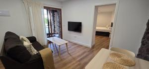 a living room with a couch and a tv at La Cueva de Villa Gardel in Icod de los Vinos