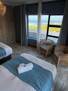 a hotel room with two beds and a view of the ocean at Oppi See Beach House in Wilderness +44 photos