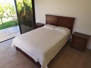 a bedroom with a bed with a wooden headboard at Casa Nébula La Cima de Dota in El Copey