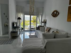 a living room with white walls and a couch at Enlightened Escape in Nea Peramos