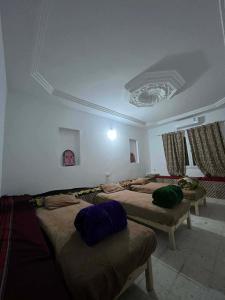 a room with three beds in a room with a ceiling at La tente in Tamaghzah