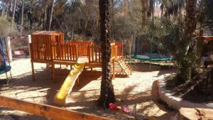 a playground with a slide and a tree at La tente in Tamaghzah