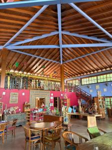 a restaurant with wooden tables and chairs and pink walls at Pousada Taman Baru in Pirenópolis