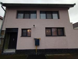 a white house with black windows and a door at Casa Pop in Oradea
