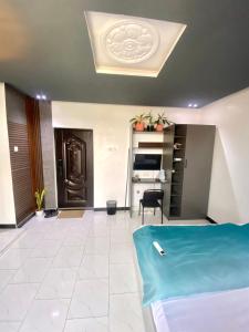 a living room with a bed and a kitchen at Cozy Studio Apartment in Accra in Accra