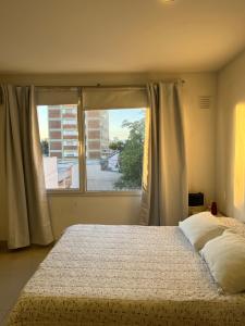 a bedroom with a bed and a large window at La Suitte in Bahía Blanca