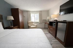 a hotel room with a large bed and a television at Hotel 8 in Fergus Falls