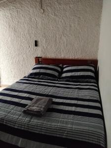 a bed with two pillows and a blanket on it at Jungle house private room in Medellín