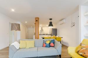 a living room with a blue couch and a kitchen at The Loghouse in Lisbon