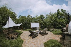a patio with two chairs and a white screen at Mobbiton Mostar - Magical Underground Retreat in Mostar