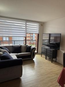 a living room with a couch and a flat screen tv at Jacinta in Puerto Montt