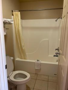 a bathroom with a toilet and a bath tub at All Star Inn in Bunkie