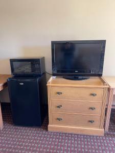 a television sitting on top of a dresser with a laptop at All Star Inn in Bunkie