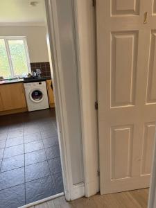 an open door to a kitchen with a washing machine at Bel City in Thornton Heath +24 photos
