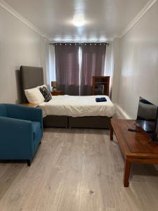 a bedroom with a bed and a couch and a table at Bel City in Thornton Heath