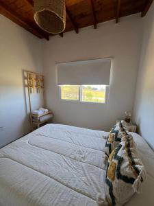 a bedroom with a large bed with a window at Casa Lobos en Chapadmalal in La Estafeta +8 photos