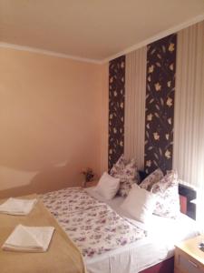 een slaapkamer met een groot bed met bloemenbehang bij City Centre Apartment in Győr