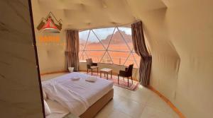 a bedroom with a bed and a table and a window at Daria Luxury Camp in Wadi Rum