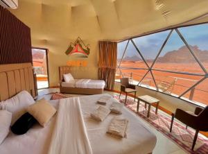 a bedroom with a bed and a view of the desert at Daria Luxury Camp in Wadi Rum