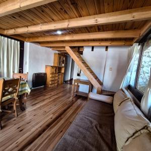 a living room with a couch and wooden floors at Aparts Duendes del Arroyo in Villa General Belgrano