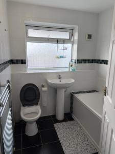 a bathroom with a toilet and a sink and a tub at Bel City in Thornton Heath