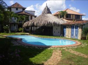 a house with a swimming pool in front of a house at El Refugio II, cerca Playa El Agua y Playa Parguito, VENEZUELA in Loma de Guerra