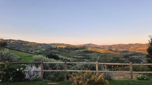 a view of a valley from a hill with a fence at Poderino - a place to feel in Cento