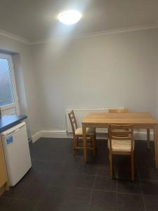 a kitchen with a table and two chairs and a light at Bel City in Thornton Heath