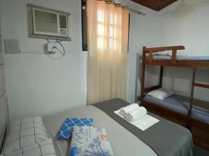 a bedroom with a bed and a bunk bed at Meu Point Itauna 1 - Paraíso a 50 Metros do Mar in Saquarema +7 photos