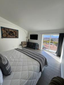 a bedroom with a large bed and a television at Blue Cow Guest Farm in Cornville