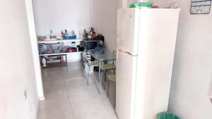 a kitchen with a white refrigerator and a table at Casa corazón del pueblo in Calima