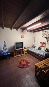 a living room with a couch and a christmas tree at casa rustica dos dormitorios con pileta in Huerta Grande +16 photos