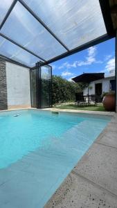 a large swimming pool with an open patio with an umbrella at Cassara Retreat in La Consulta