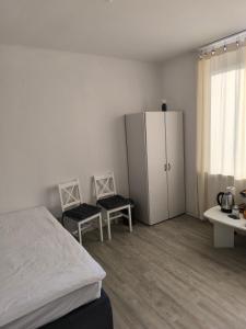 a bedroom with a bed and two chairs and a cabinet at Central Hostel Nurnberg in Nuremberg +18 photos