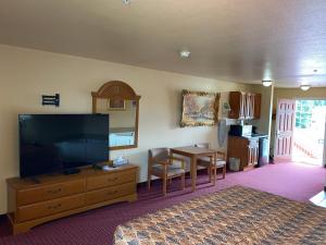 a bedroom with a large television and a dining table at Sunshine inn in Centre