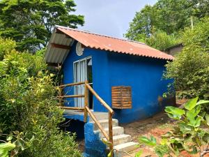 a blue tiny house with a red roof at Chalé Pedacinho do Céu in Mairiporã