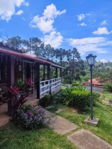 a house with a street light in the grass at Chalé Pedacinho do Céu in Mairiporã