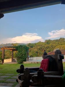 a view from the porch of a house with a couch at Chalé Pedacinho do Céu in Mairiporã +4 photos
