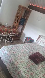 a bedroom with a bed and a table and chairs at Chalé Pedacinho do Céu in Mairiporã