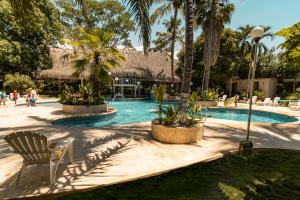a resort swimming pool with a chair and palm trees at Palma Serena Finca Hotel in Santa Fe de Antioquia